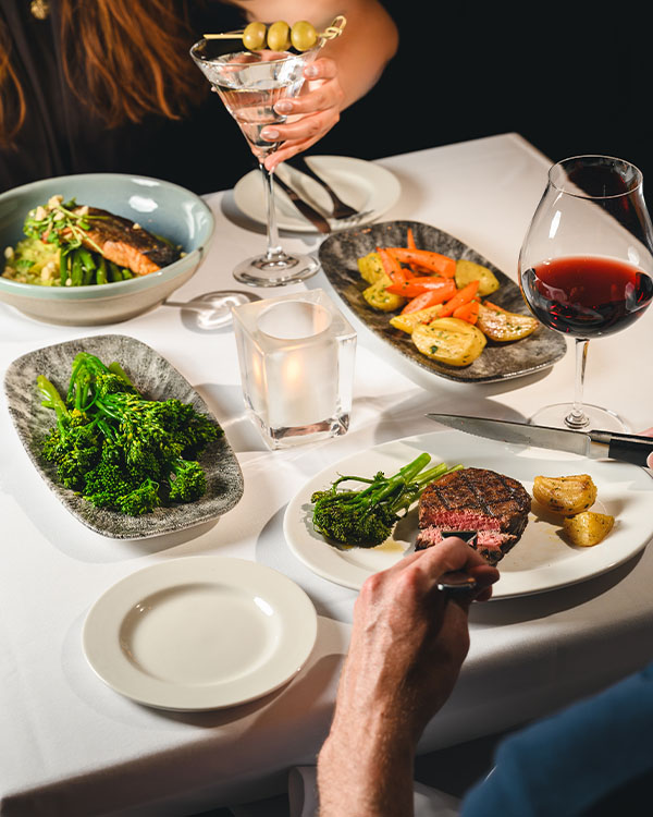 Vintage Chophouse Dinner – Steak, Salmon and Wine Vintage Chophouse fine dining table with steak, salmon, vegetables, red wine and martini